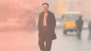 Mann läuft durch schneebedeckte Straße.