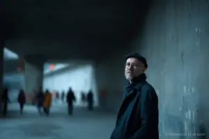 Mann steht in urbaner Umgebung.