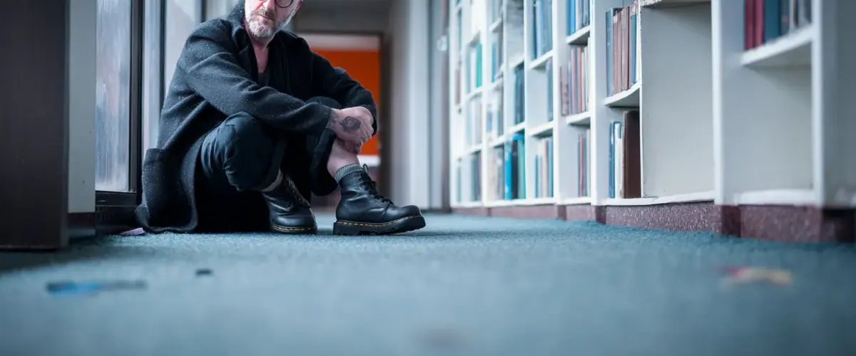 Mann vor Bücherregal