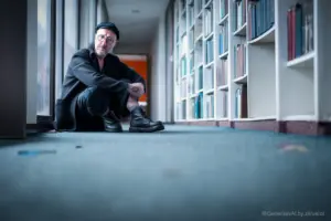 Mann vor Bücherregal